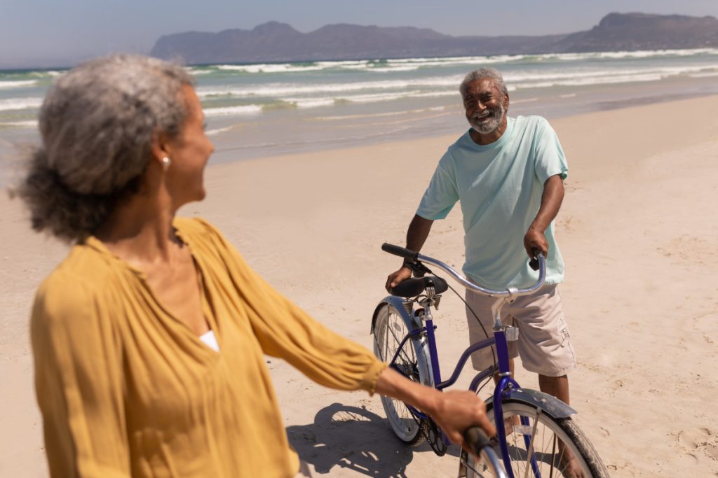 Retired couple on bikes at the beach
